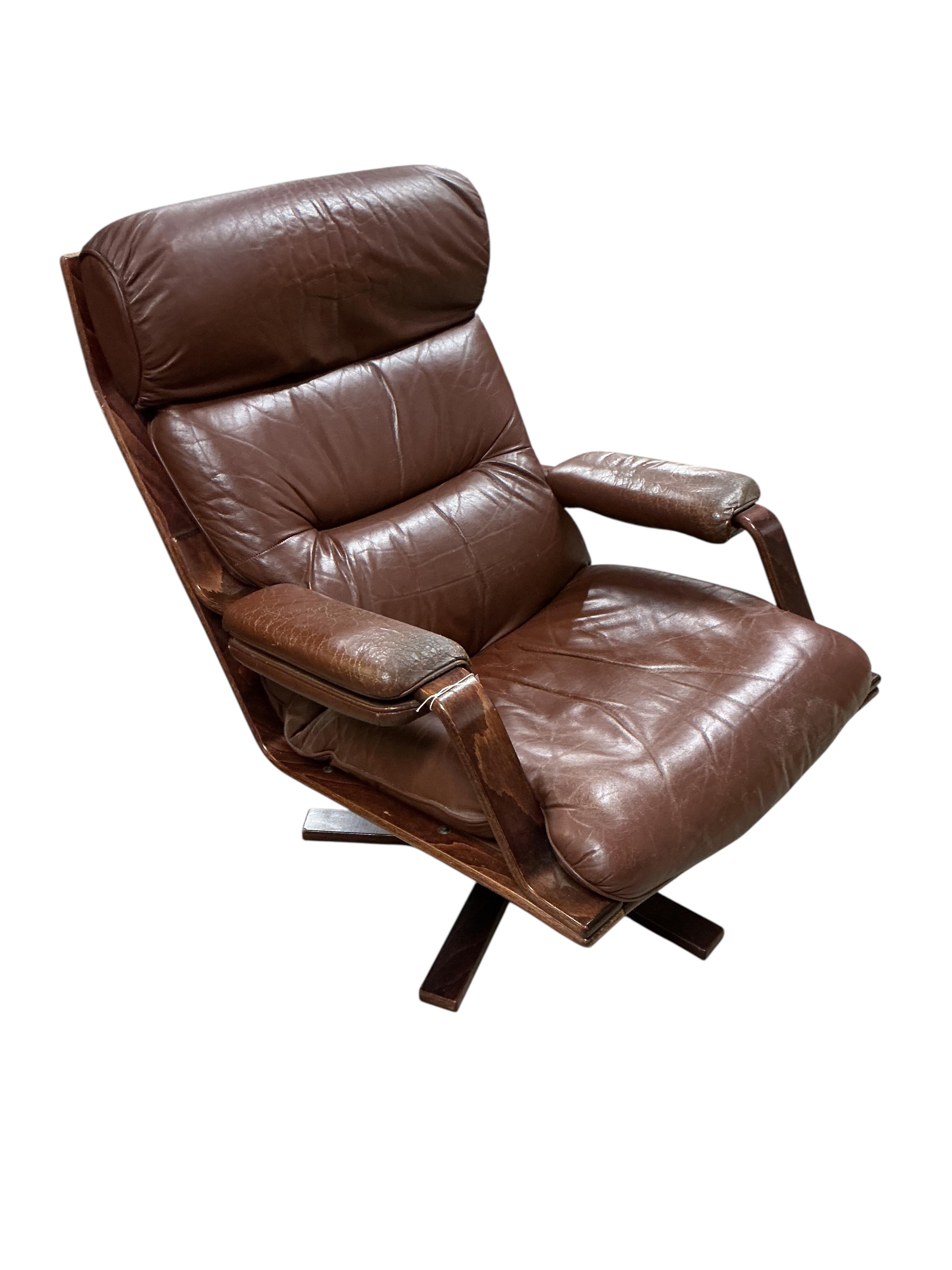 A mid century brown leather swivel chair, width 78cm, depth 90cm, height 96cm together with a footstool